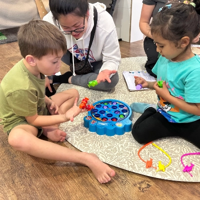 Children playing a game with a teacher in nursery.
