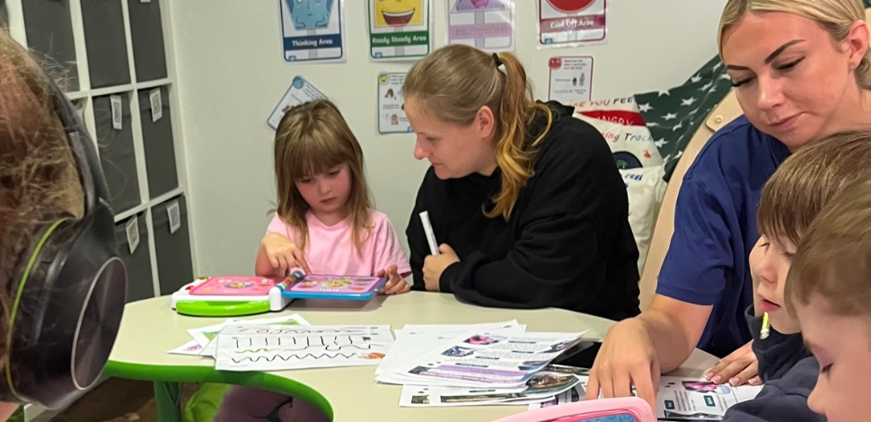 A nursery setting with teachers and children.