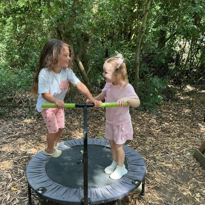 Two children playing on a trampoline.