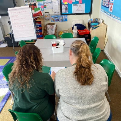 Two teachers working together in a school classroom.